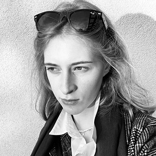 rebelious blonde girl wearing a jacket and sunglasses in a black and white picture